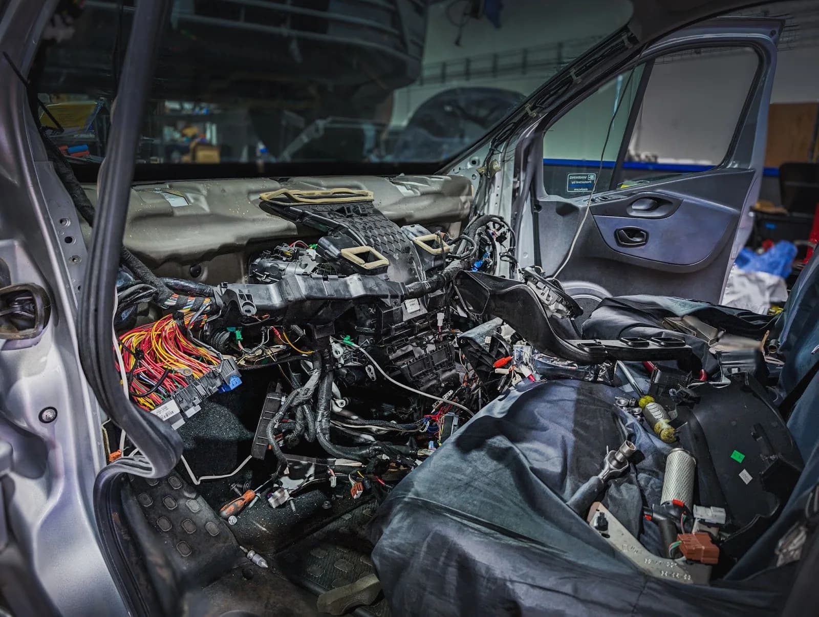 A car interior with exposed wiring during an auto electrical repair