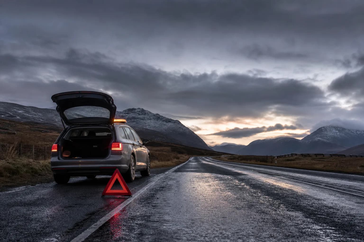 A broken-down car on a Scottish roadside at dusk with a warning triangle