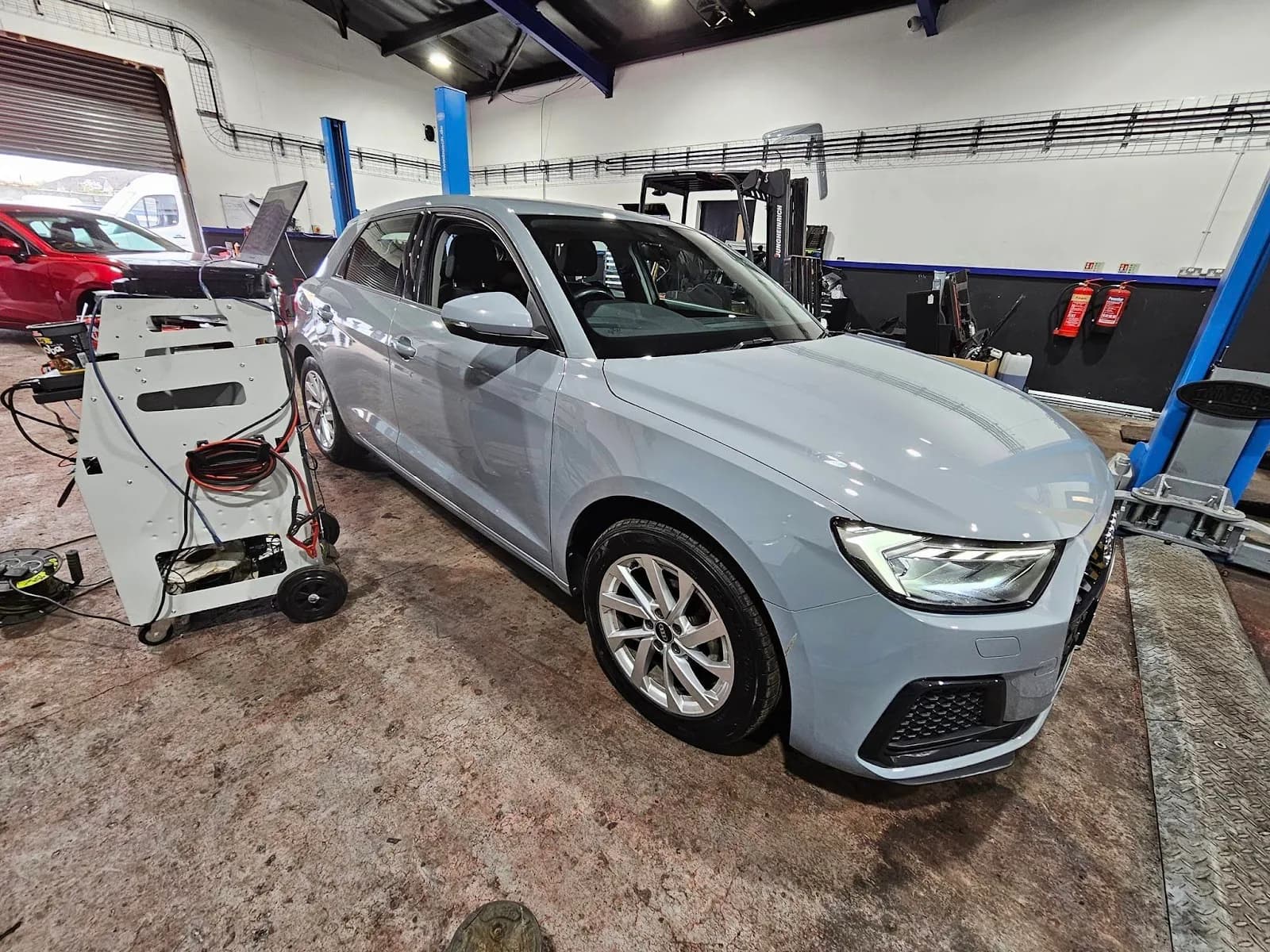 A car in the MechTronic garage raised on a vehicle lift